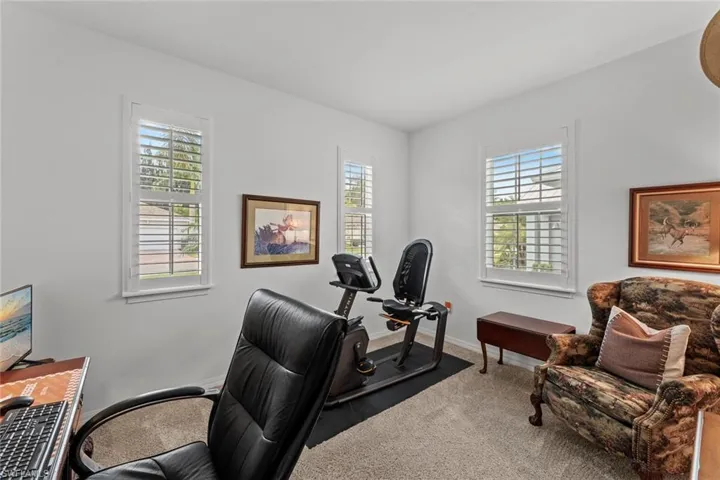 Bedroom 3 with carpet, ceiling fan/light rough-in, NEW IMPACT GLASS WINDOWS (December 2020), and NEW PLANTATION SHUTTERS (June 2020)