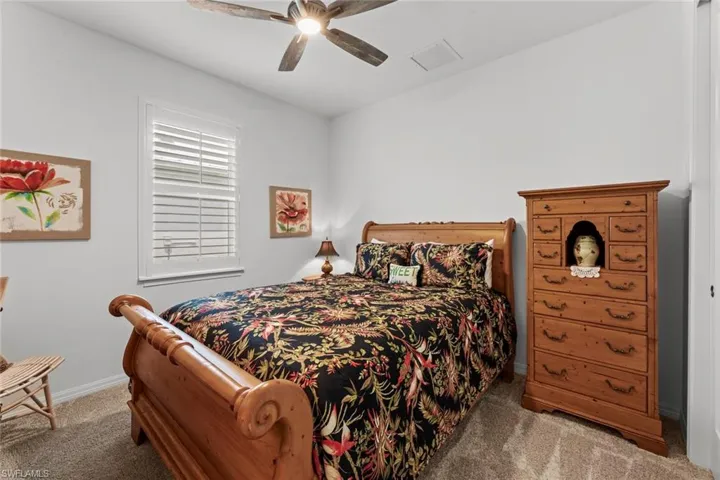 Bedroom 4 with carpet, NEW IMPACT GLASS WINDOWS (December 2020), NEW CEILING FAN/LIGHT (June 2020), and NEW PLANTATION SHUTTERS (June 2020)
