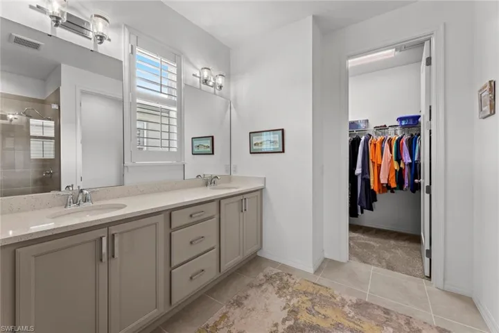 Primary bath leads to a large walk-in closet. NEW IMPACT GLASS WINDOWS (December 2020), and NEW PLANTATION SHUTTERS (June 2020)