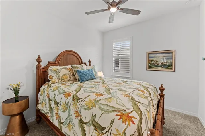 Bedroom 2 with carpet, ENSUITE BATH, NEW IMPACT GLASS WINDOWS (December 2020), NEW CEILING FAN/LIGHT (June 2020), and NEW PLANTATION SHUTTERS (June 2020)