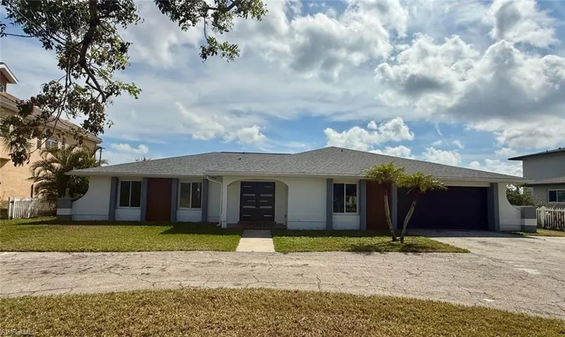 Single story home featuring a garage, fence, driveway, stucco siding, and a front yard