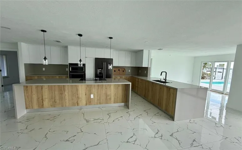 Kitchen featuring light countertops, a spacious island, and white cabinetry