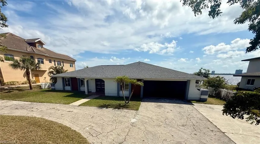 Single story home with stucco siding, a front yard, fence, a garage, and driveway
