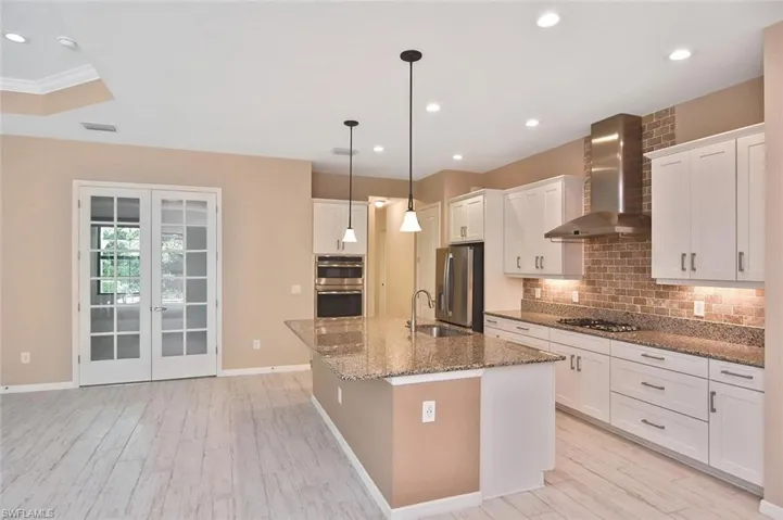 The office/den or creative space with French door entry is just off of the Kitchen