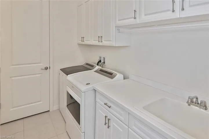 The Laundry Room with washer, dryer, plenty of storage, and utility sink