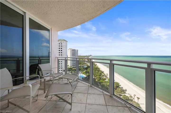 Balcony featuring view of water and beach