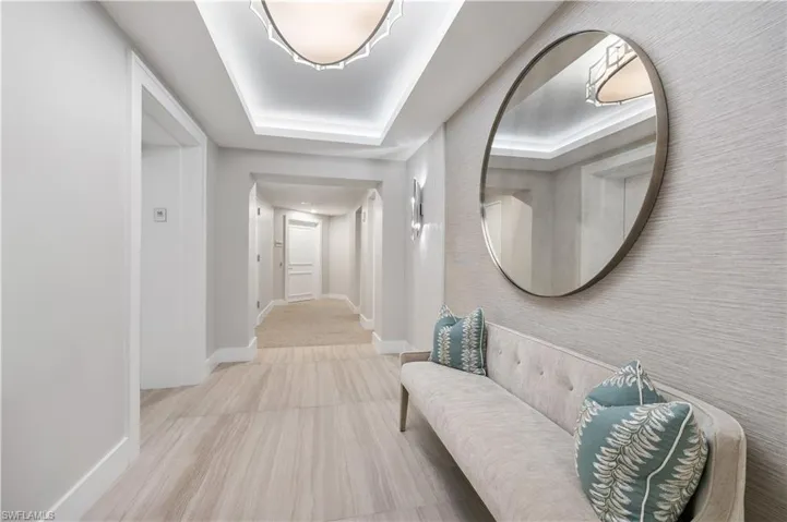 Building Hallway featuring baseboards and a tray ceiling
