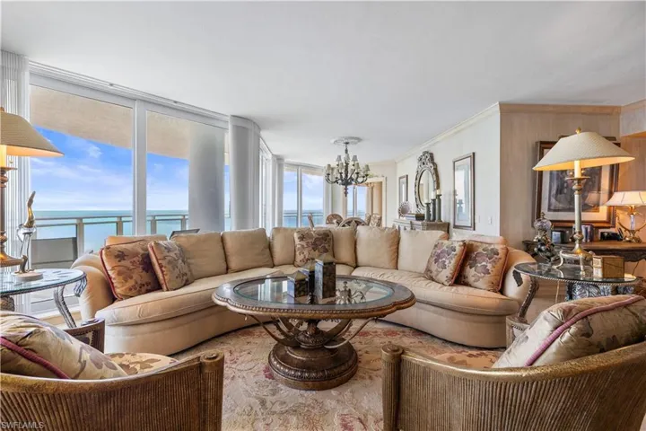 Living area with a chandelier, ornamental molding, and a water view