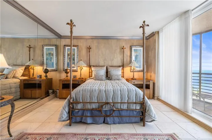 Bedroom featuring access to exterior, crown molding, multiple windows, a water view, and wooden walls