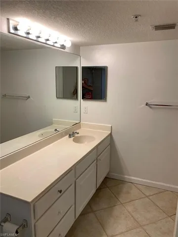 Bathroom featuring vanity, a textured ceiling, and tile patterned floors