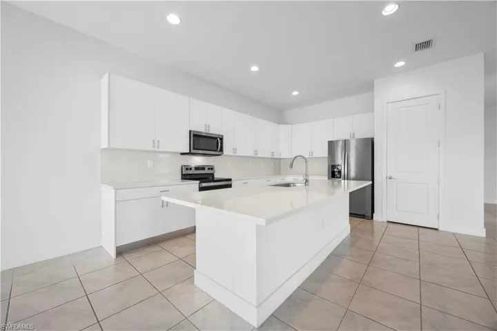 Kitchen featuring kitchen island with quartz countertops, modern cabinetry, and stainless steel appliances.