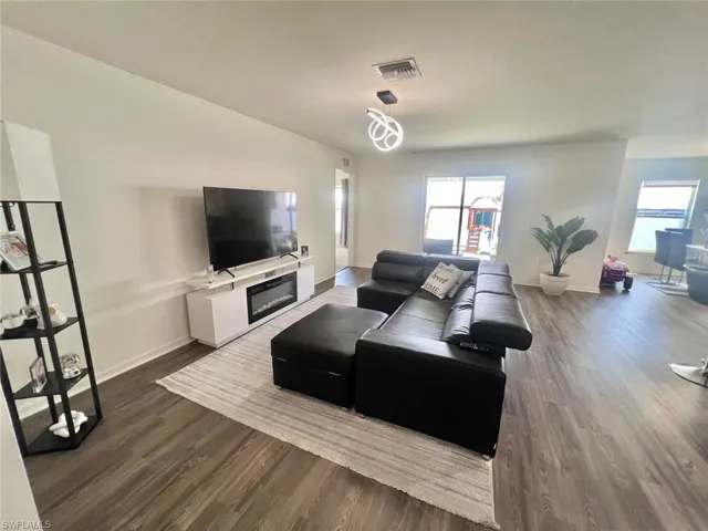 Living area with dark wood-style flooring and plenty of natural light