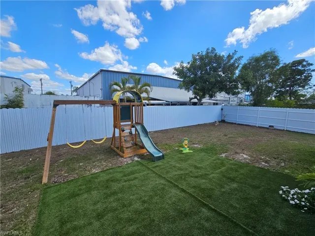 View of playground with a fenced backyard