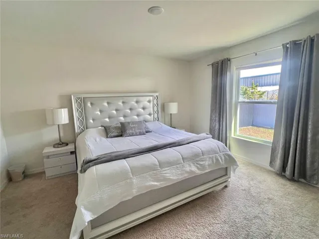 Bedroom featuring carpet flooring and baseboards