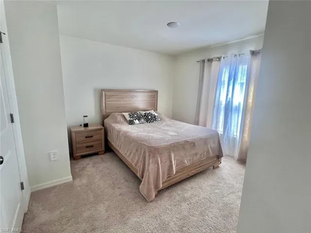 Bedroom featuring carpet flooring and baseboards