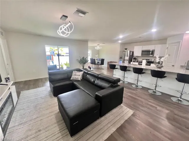 Living area featuring dark wood-style floors and recessed lighting
