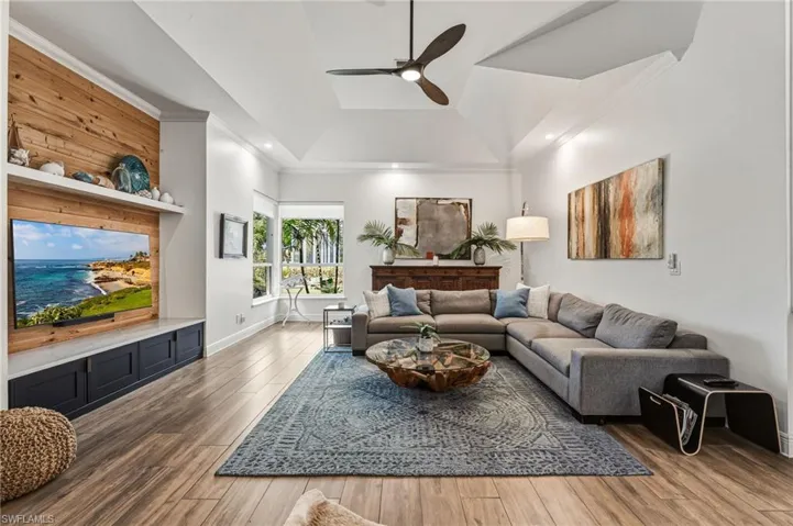This additional living area features a striking cypress focal wall, expansive picture windows, and custom tray ceilings, creating a warm and refined space filled with natural light.