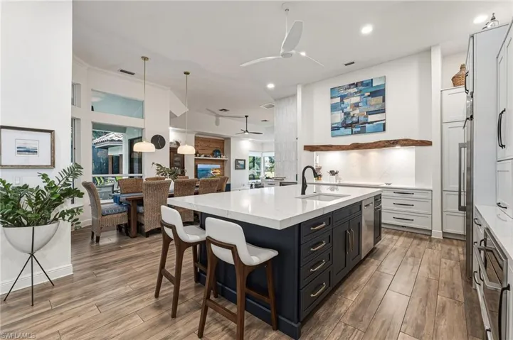 A true chef’s masterpiece, this one-of-a-kind kitchen features a stunning walnut inset above the induction cooktop, complemented by a sleek quartz backsplash, and flows effortlessly into the formal dining area and additional living space.