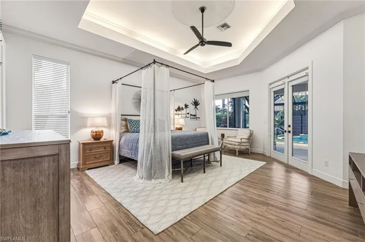 The primary bedroom features an uplighted tray ceiling, private access to the lanai, and a luxurious ensuite bath.