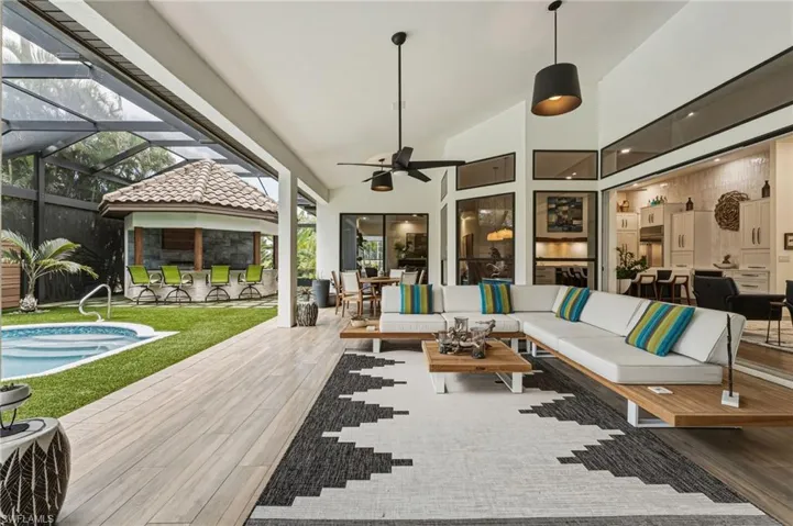 The enormous under-truss lanai is designed for effortless entertaining and year-round relaxation in any weather. The cabana is well-appointed with a Coyote grill and Big Green Egg, complemented by a pecky cypress inset ceiling and striking blue porcelain tile backsplash, creating a stylish and functional outdoor culinary retreat.