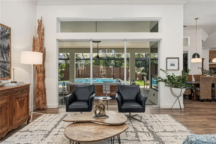 The entry into the home captures serene views of the tranquil outdoor space and oversized lanai, while transom windows invite an abundance of natural light to pour in.