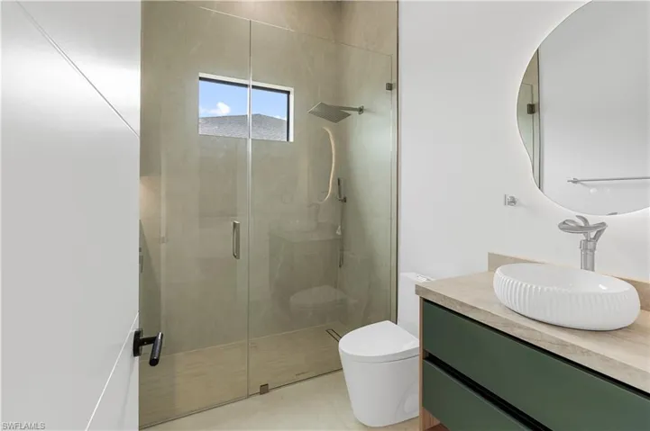 Full bath featuring a shower stall and vanity
