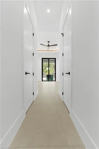 Hallway with light tile patterned floors and recessed lighting