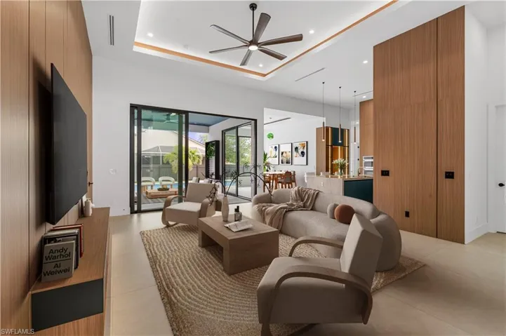 Living room featuring recessed lighting, a ceiling fan, and a tray ceiling
