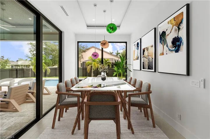 Dining room with a tray ceiling and light tile patterned flooring