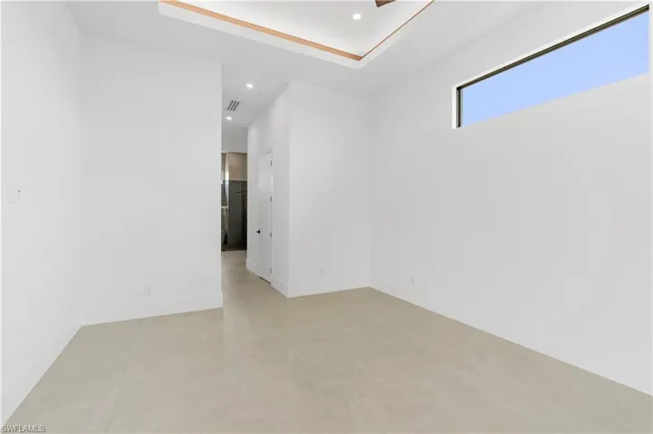 Unfurnished room with recessed lighting, a tray ceiling, and light tile patterned flooring