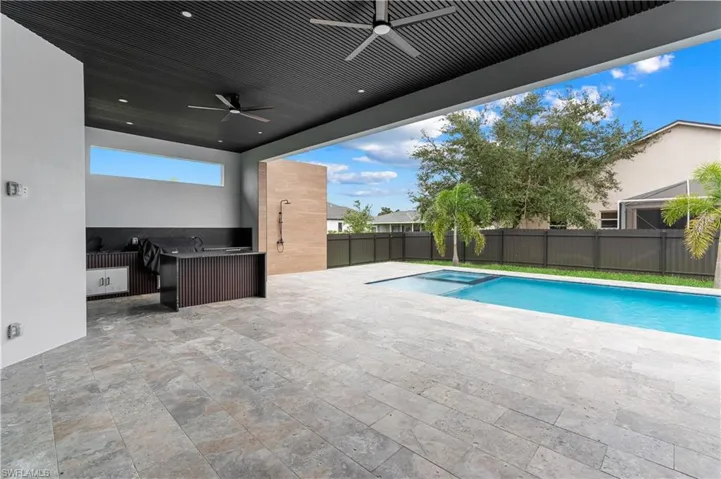 View of pool with a fenced backyard, a patio area, a pool with connected hot tub, and a ceiling fan