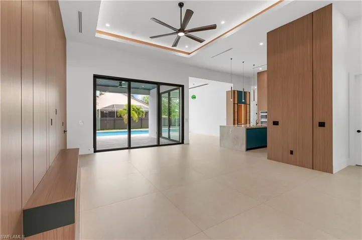 Spare room featuring a ceiling fan, recessed lighting, a tray ceiling, and light tile patterned flooring