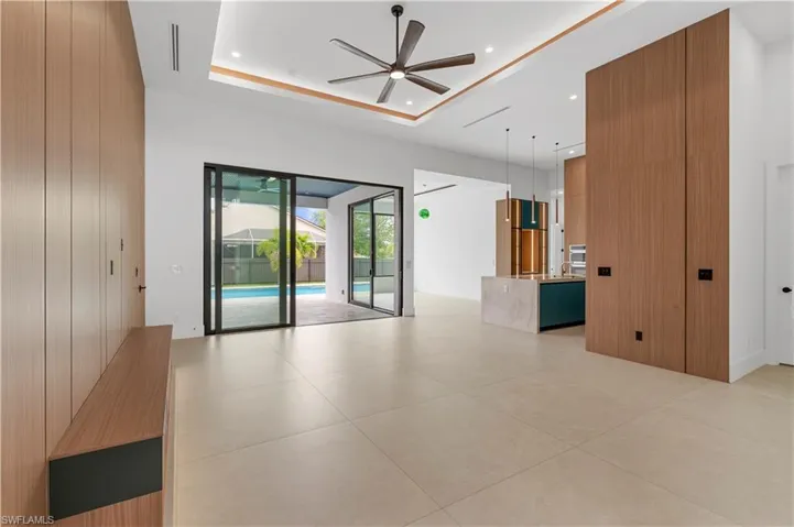 Empty room featuring ceiling fan, recessed lighting, light tile patterned floors, and a raised ceiling