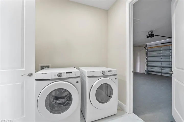 Laundry room featuring washing machine and clothes dryer and a garage