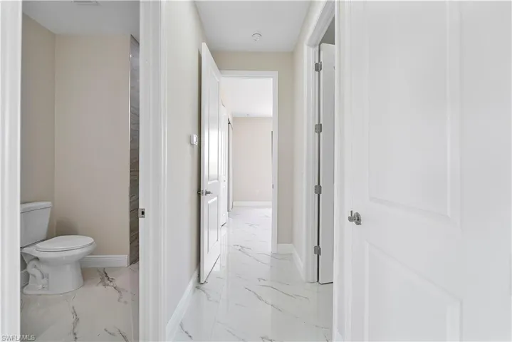Hall with baseboards and light marble finish flooring