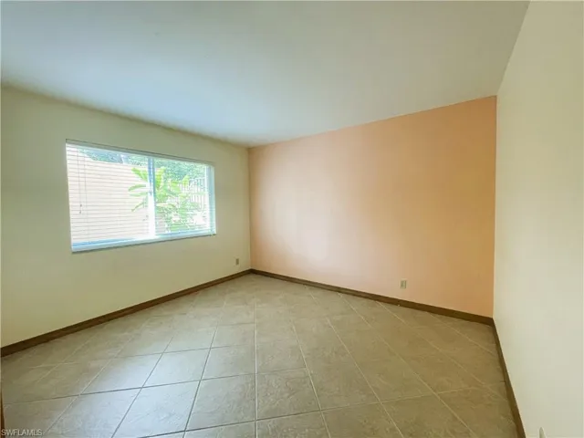 Empty room featuring baseboards and light tile patterned flooring