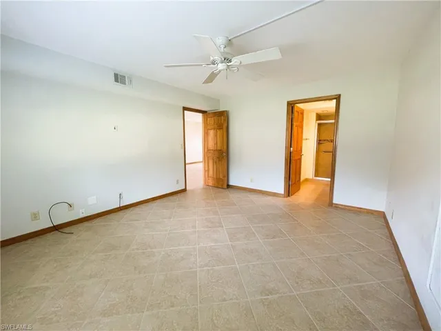 Unfurnished room featuring light tile patterned floors and ceiling fan