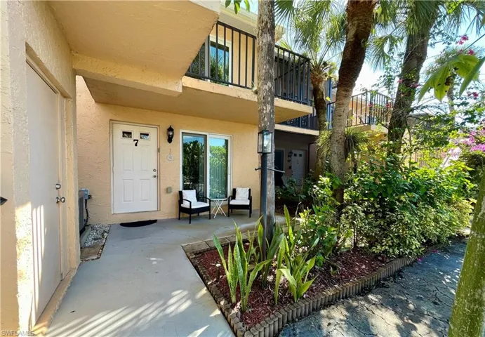 View of exterior entry with stucco siding and a patio area