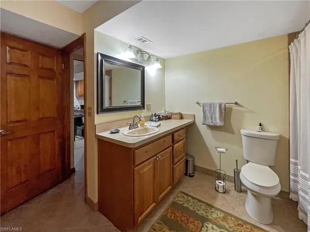 Bathroom with light tile patterned floors, vanity, and a shower with curtain