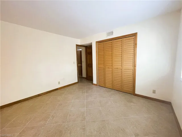 Unfurnished bedroom with a closet and light tile patterned floors