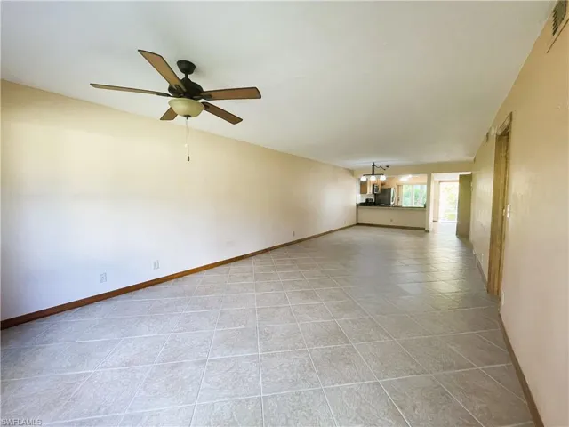 Unfurnished living room featuring ceiling fan and light tile patterned flooring