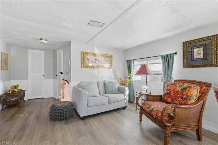 Living room featuring wood finished floors and a wainscoted wall