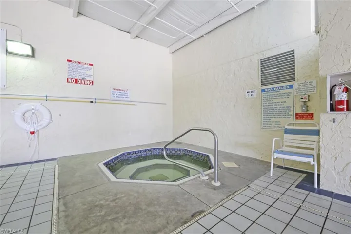 View of pool with a hot tub