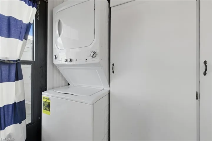 Laundry room with stacked washer and clothes dryer