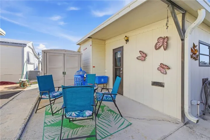 View of patio with outdoor dining area and a shed