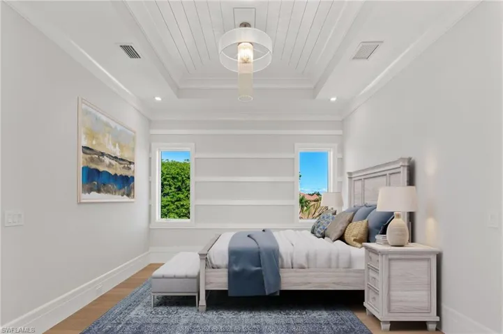 Bedroom featuring hardwood / wood-style flooring and a raised ceiling