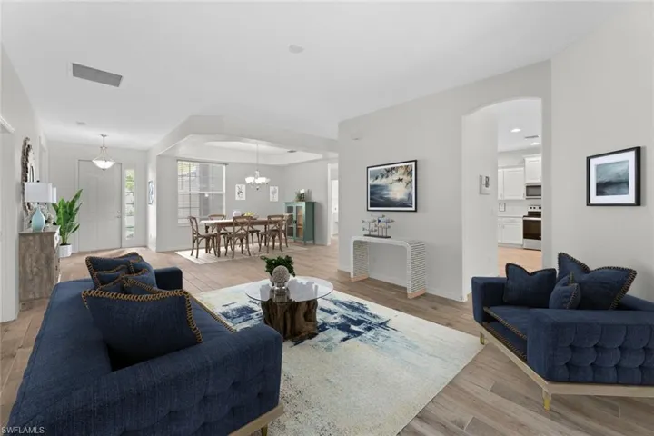 Virtually staged Living room featuring an inviting chandelier and light wood-type flooring