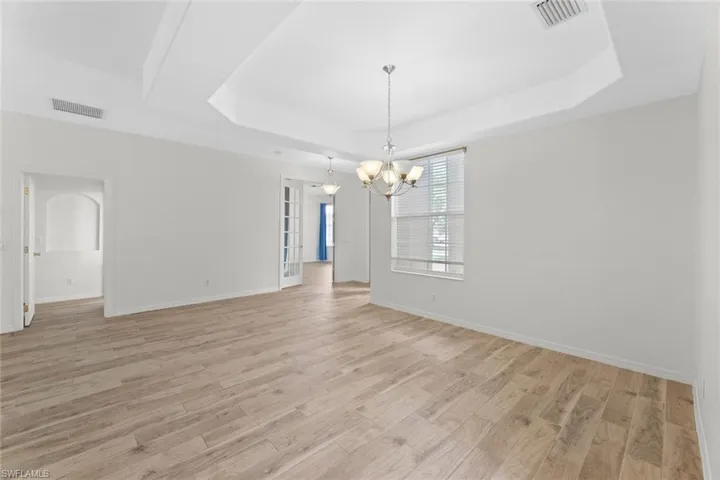 Dining area, an inviting chandelier, and a raised ceiling