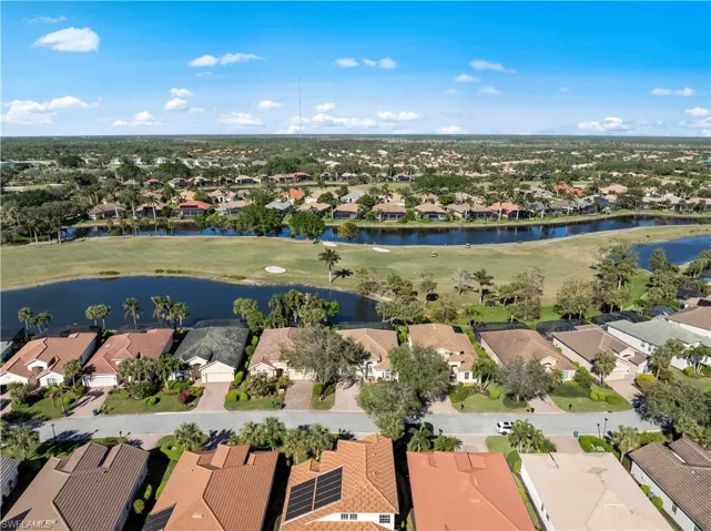 Aerial view of residential area with a nearby body of water and a local golf course