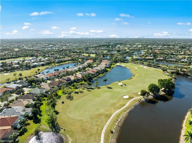 Aerial view of property's location featuring a golf club, nearby suburban area, and a nearby body of water